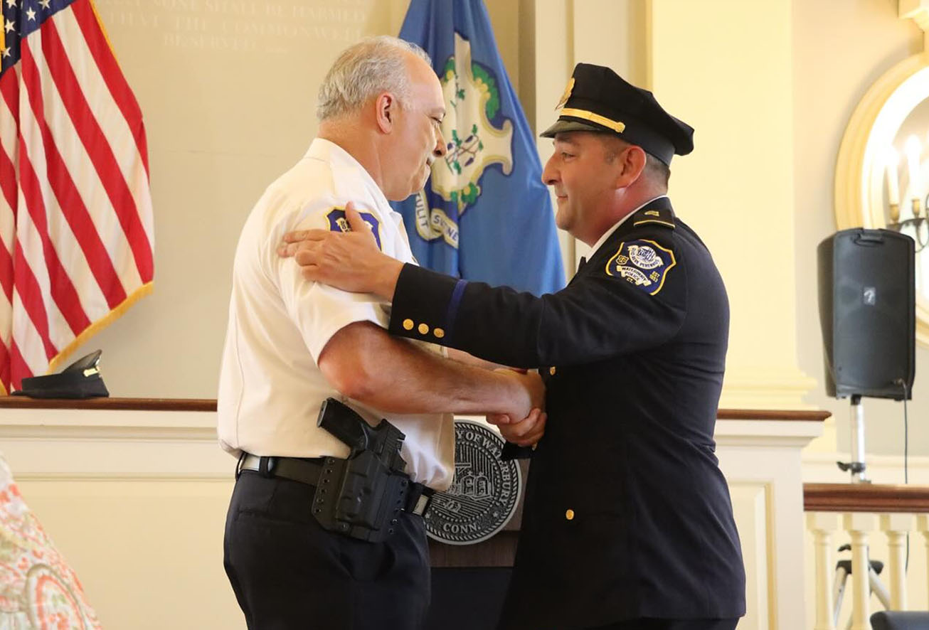 Two Waterbury police command staff officers shaking hands during a ceremony