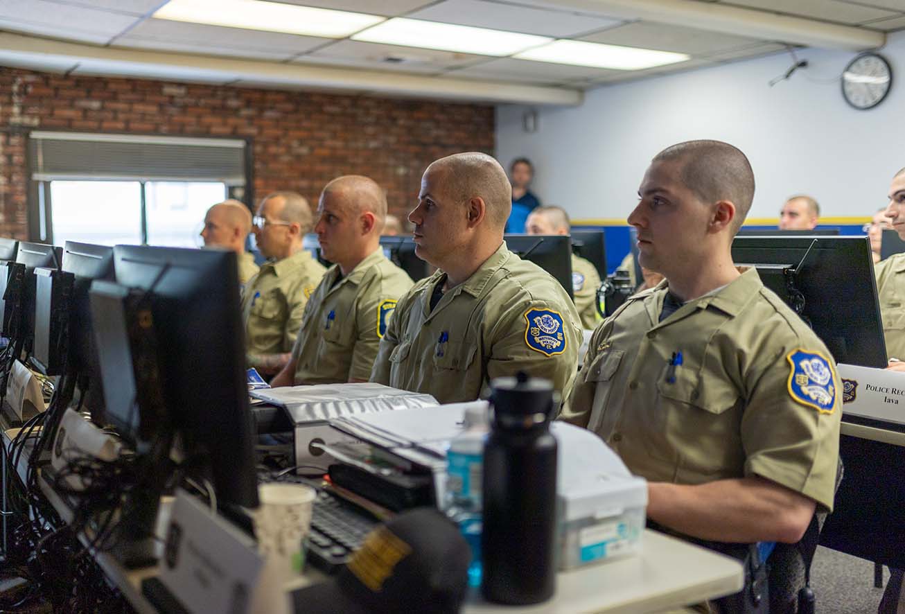 A group of Waterbury police recruits attending a technical training class in front of computer monitors