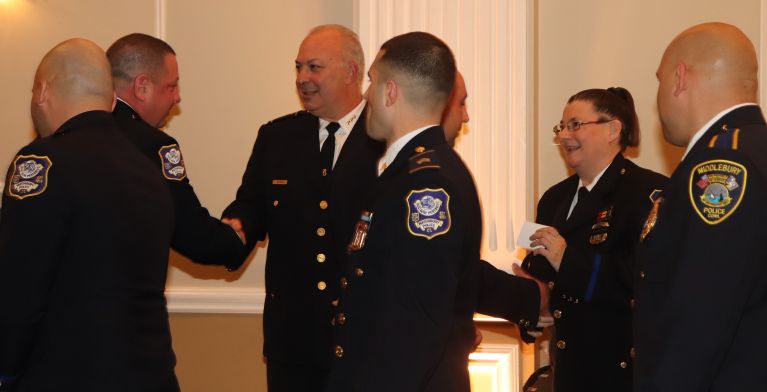 An officer receiving a pin from a child in an award ceremony